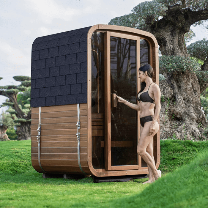 סאונת חוץ מסורתית Auki-1400 מבית ORans עשויה עץ Walnut עם דלת זכוכית כהה, עיצוב יוקרתי וחוויית סאונה פינית לגינה